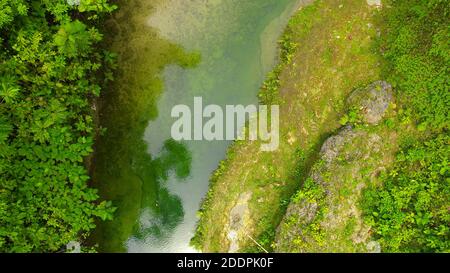 Luftaufnahme der Steine im Fluss unter einem Wasserstrom. Wasser fließt über Steine in einem Fluss. Stockfoto