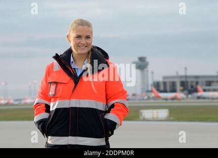 03. November 2020, Brandenburg, Schönefeld: Julia Schulze, Mitarbeiterin des Vorfeldservice am Flughafen Berlin Brandenburg (BER), steht auf der Südbahn vor der Kulisse von Turm und Terminal 1. Julia Schulze führte das Flugzeug der Lufthansa während der Eröffnungsfeier des Hauptstadtflughafens zum Gate. Während einer zweiwöchigen Probe mit Generalproben wurde die Choreographie mit geschleppten Flugzeugen geübt, um sicherzustellen, dass alles reibungslos lief. Foto: Soeren Sache/dpa-Zentralbild/ZB Stockfoto