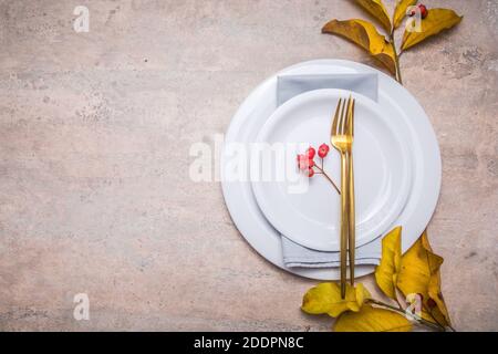 Thanksgiving Dinner-Setting, gefallene Blätter mit Teller und Besteck. Stockfoto