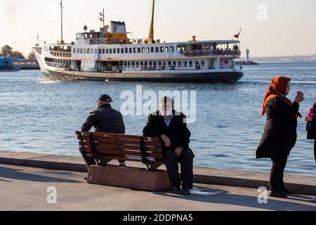 Mann mittleren Alters sitzt auf der Bank. Menschliche Landschaften von der Küste Kadikoys während der Tage der Coronavirus-Pandemie am 21. November 2020 in Istanbul, Türkei Stockfoto