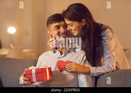 Frau gibt ihm ein Geschenk und einen valentinstag zum Valentinstag. Stockfoto