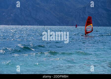 Surfer fangen die Brise auf dem stürmischen Gardasee Italien Mit den Bergen im Hintergrund Stockfoto