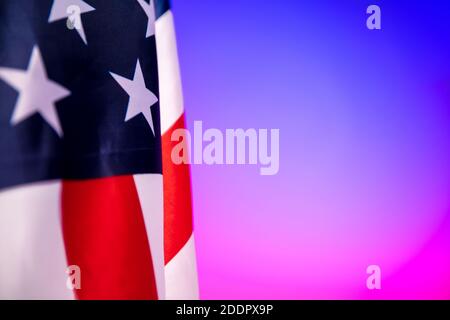 Nahaufnahme der amerikanischen Flagge auf rosa-blauem Hintergrund in Neonlicht. Stockfoto
