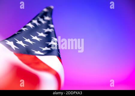 Nahaufnahme der amerikanischen Flagge auf rosa-blauem Hintergrund in Neonlicht. Stockfoto