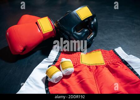 Draufsicht auf Boxhandschuhe, Shorts, Helm und Bandage Tape auf schwarzem Hintergrund Stockfoto