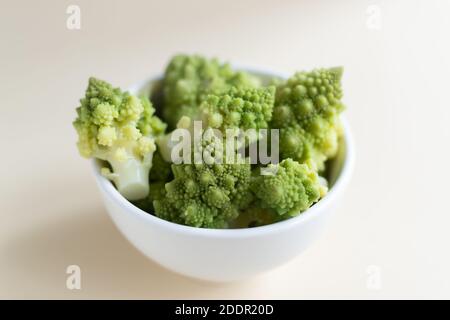 Romanesco Blumenkohl in einer weißen Schale auf hellem Hintergrund. Gesunde Ernährung Konzept. Speicherplatz kopieren. Nahaufnahme. Horizontale Ausrichtung. Stockfoto