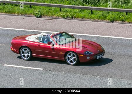 2004 Red Jaguar XKR Cabrio Auto; Fahrzeugverkehr, bewegliche Fahrzeuge, Autos, Fahrzeug fahren auf britischen Straßen, Motoren, Fahren auf der Autobahn M6 Autobahn britischen Straßennetz. Stockfoto