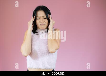 Junge hübsche blonde Frau tragen wolle winter Pullover über rosa isoliert Hintergrund mit der Hand auf den Kopf für Schmerzen im Kopf, weil Stress. Leiden mi Stockfoto