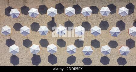 Blick von oben auf den Strand mit weißen Sonnenschirmen. Stockfoto