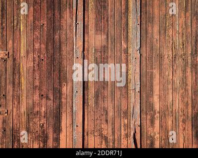 Rustikale hölzerne Hintergrund einer Scheune Wand - Planken aus verwitterten Kiefer rot lackiertem Holz mit Knoten, Löcher und Nägel Stockfoto