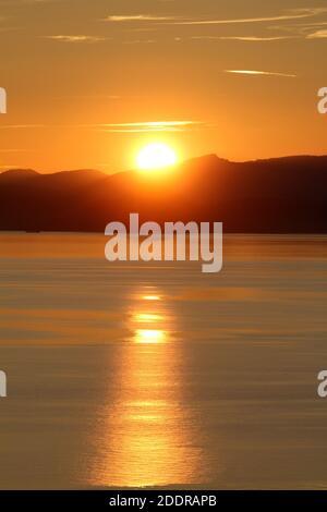 Isle of Arran, Schottland, Großbritannien. Sonnenuntergang über der Insel vom Strand in Ayr. Bekannt als der schlafende Riese aufgrund seiner Umrisse, besonders von der Ayrshire Coast aus gesehen. Stockfoto