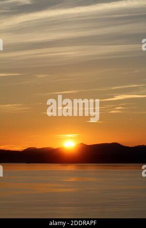 Isle of Arran, Schottland, Großbritannien. Sonnenuntergang über der Insel vom Strand in Ayr. Bekannt als der schlafende Riese aufgrund seiner Umrisse, besonders von der Ayrshire Coast aus gesehen. Stockfoto