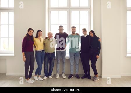 Gruppenportrait am Fenster von glücklichen positiven, vielfältigen Menschen verschiedener Geschlechter, Rassen und Altersgruppen. Stockfoto