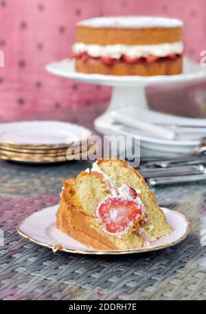 Schöne große Scheibe Licht hausgemachten Victoria Sponge Kuchen mit Erdbeeren und frische Sahne in der Mitte Stockfoto
