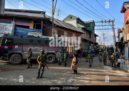 Eine Frau geht an indischen Soldaten vorbei, die in der Nähe des Angriffs in Srinagar, der Sommerhauptstadt von Jammu und Kaschmir, wachsam stehen.zwei indische Soldaten wurden bei einem militanten Angriff am Stadtrand von Srinagar getötet. Die Soldaten waren Teil einer Armee Patrouille Team, das unter schweren Beschuss von Militanten kam, sagte die Polizei. Stockfoto
