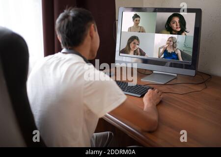 Rückansicht des Geschäftsmannes, der mit seinen Kollegen über Plan in der Videokonferenz spricht. Multiethnisches Geschäftsteam mit Laptop. Gruppe von Menschen intelligente worki Stockfoto