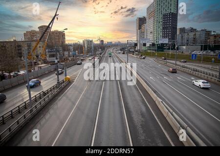 Moskau, Russland - November 2020: Autos fahren auf breiter mehrspuriger Schnellstraße vor dem Hintergrund urbaner Häuser Stockfoto