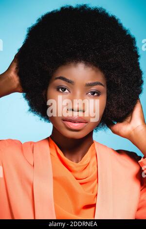 afroamerikanische junge Frau in orange stilvolles Outfit isoliert auf Blau Stockfoto