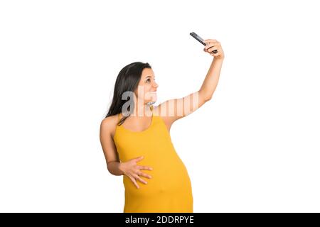 Schwangere Frau nimmt ein Selfie mit Handy. Stockfoto