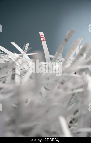 Ein Bündel geschredderter Papierstreifen und auf einem Streifen wird ein Dollar-Symbol gedruckt. Stockfoto