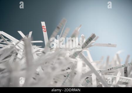 Ein Bündel geschredderter Papierstreifen und auf einem Streifen wird ein Dollar-Symbol gedruckt. Stockfoto