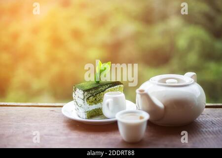 asiatische Frau Hand mit einer Tasse Tee auf Holz Am Tisch gab es eine wunderschöne Teeplantage und einen Berg im Morgens Stockfoto