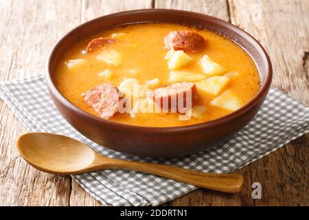 Würzige dicke Kartoffelsuppe mit Würstchen und saurer Sahne Nahaufnahme in einem Teller auf dem Tisch. Horizontal Stockfoto