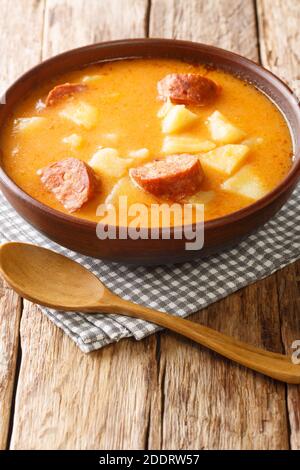 Traditionelle ungarische dicke Kartoffelsuppe mit Würsten Nahaufnahme in einem Teller auf dem Tisch. Vertikal Stockfoto