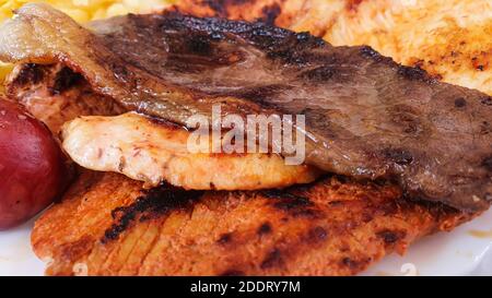 Nahaufnahme von gemischten gegrillten Steaks auf einem Teller, mit Schweinefleisch, Rindfleisch, Huhn und Kartoffeln, selektiver Fokus Stockfoto