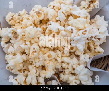 Draufsicht auf das salzige Popcorn im gewebten Bambuskorb für den Einsatz im Kino. Stockfoto