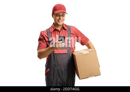 Männlicher Kurier in einer Uniform, der eine Schachtel hält und schreibt Auf einem Mobiltelefon, das auf weißem Hintergrund isoliert ist Stockfoto