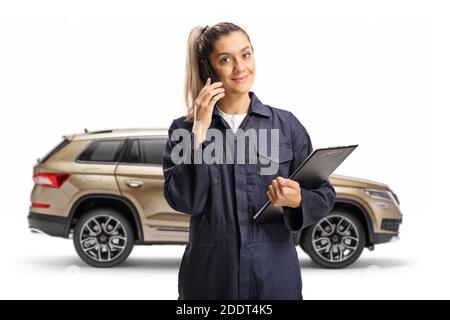 Weibliche Auto Mechaniker stehen vor suv und sprechen Auf einem Mobiltelefon, das auf weißem Hintergrund isoliert ist Stockfoto