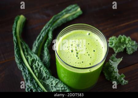 Glas frischen grünen Saft mit Grünkohl auf einem gemacht Dunkle Holzoberfläche Stockfoto