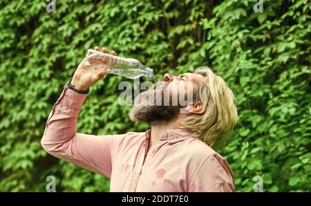 Die Flasche ablassen. Tägliche Wasseraufnahme. Durstige männliche Modell genießen erfrischende Getränk. Gesunde Ernährung und Trinken. Trinkwasser. Schöner Mann, der frisches Wasser aus der Flasche trinkt. Morgendliche Routine. Stockfoto