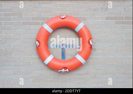 Roter Rettungsring an einer Ziegelwand eingehängt Stockfoto