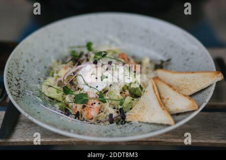 Nahaufnahme von frischem veganem Salat mit Garnelen im Freien Café auf der Terrasse Stockfoto
