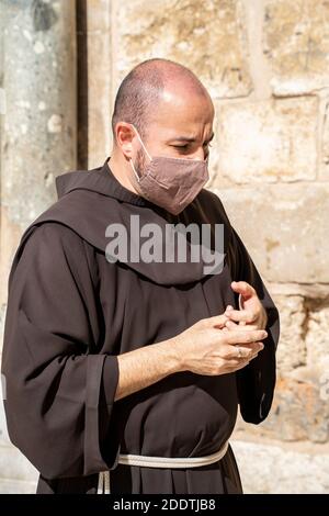 Jerusalem, Israel - 21. November 2020: Ein franziskanermönch mit einer schützenden Anti-Virus-Maske in Jerusalem, Israel Stockfoto