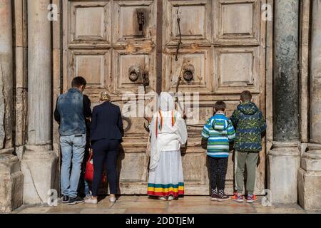 Jerusalem, Israel - 21. November 2020: Gläubige beten an den verschlossenen Türen (wegen Corona-Virus) der Kirche des heiligen Grabes, Jerusalem, Stockfoto