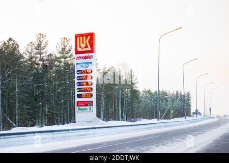 Surgut, Russland-01.25.2020: Informationstafel der Lukoil Tankstelle auf der Straße, Winter Kraftstoffpreise.Ökologische Treibstoffübertragung, verschwommener Hintergrund Stockfoto