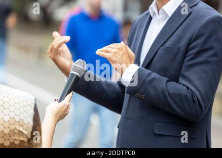 Reporter macht Medieninterview mit unkenntlichen Person. Vox populi Konzept. Stockfoto