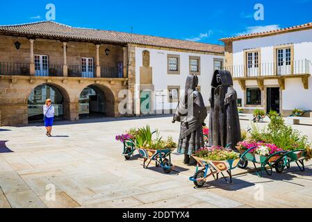 Plaza Joao III, zwei Statuen aus Bronze mit den typischen regionalen Kostümen der Region Tras os Montes, im Hintergrund das Museu da Terra de Stockfoto