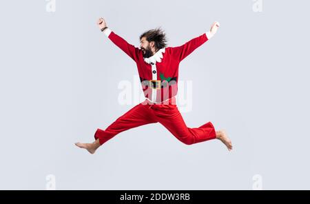 Glücklicher bärtiger Mann im roten weihnachtsmann Kostüm springen hoch und fühlen Glück über weihnachtseinkäufe, Neujahr. Stockfoto