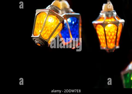 Glühende Weihnachtslichter in schwarzer Nacht. Bunte Feen weihnachtslichter mit Vintage Laterne förmigen Lampen. Stockfoto