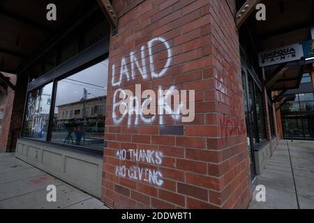 Portland, USA. November 2020. "Land Back"-Graffiti ist auf dem Fenster der Umpqua Bank in der Southeast Hawthorne Street in Portland, Oregon, am 26. November 2020 abgebildet, nach einem Aufruf zum Handeln am Thanksgiving-Abend, der indigene Demonstranten dazu aufforderte, Symbole des Kolonialismus, des Kapitalismus und der Gentrifizierung anzugreifen. (Foto: Alex Milan Tracy/Sipa USA) Quelle: SIPA USA/Alamy Live News Stockfoto