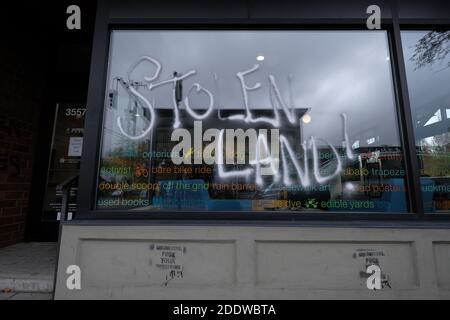 Portland, USA. November 2020. Das Graffiti von 'Stolen Land' ist am 26. November 2020 auf dem Fenster der Umpqua Bank in der Southeast Hawthorne Street in Portland, Oregon, nach einem Aufruf zum Handeln am Thanksgiving-Abend zu sehen, der indigene Demonstranten dazu aufforderte, Symbole des Kolonialismus, des Kapitalismus und der Gentrifizierung anzugreifen. (Foto: Alex Milan Tracy/Sipa USA) Quelle: SIPA USA/Alamy Live News Stockfoto