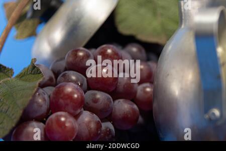 Frische Traubenfrüchte und Beeren. Blauer Hintergrund . Zutat für Säfte und Wein. Traubenbeeren in Aluminium. Stockfoto