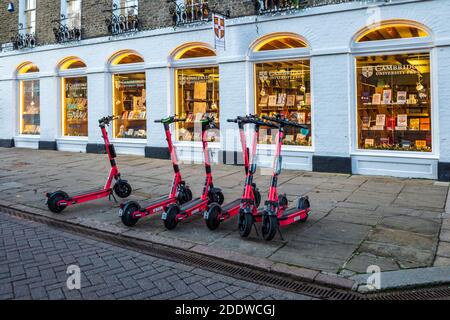 VOI Elektro-Scooter zu mieten auf einer Straße im historischen Zentrum von Cambridge. VOI Technology E-Scooter zum Mieten in einer Cambridge Straße. Stockfoto