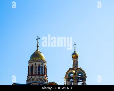 Spitze der christlich-orthodoxen Kirche mit goldenen Kuppeln und Kreuze gegen den blauen Himmel Stockfoto