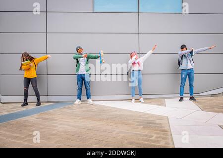 Multiethnische Menschen tanzen den Dab Tanz halten soziale Distanz während Die Zeit des Coronavirus - spielerische Schüler machen lustig Posen mit Prote Stockfoto