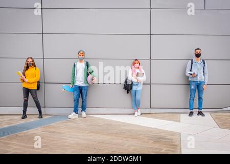 Junge Multitnic Leute warten in der Schlange vor dem Shop Markt während Keeping Social Distanz - Gruppe von jungen Freunden warten auf Gehen in die Univ Stockfoto